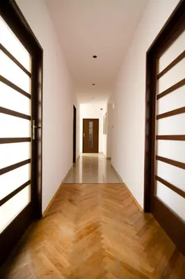 an empty hallway with a door and wooden floors at Cracow bb in Kraków