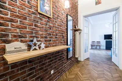 a brick wall in a hallway with a wooden bench at Native Apartments Batorego 7- Bardzo ciche i spokojne miejsce in Kraków