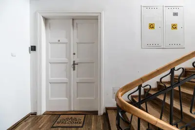 a hallway with a white door and a staircase at Native Apartments Batorego 7- Bardzo ciche i spokojne miejsce in Kraków