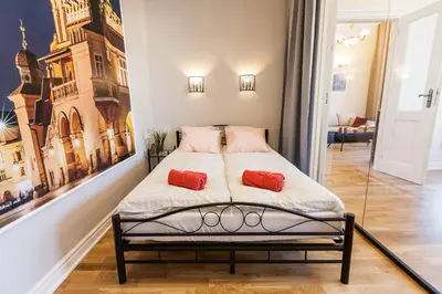 a bedroom with a bed with two red pillows on it at Vintage Podzamcze Apartment in Kraków