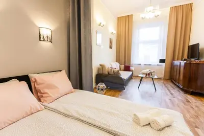 a bedroom with a bed and a couch and a chair at Vintage Podzamcze Apartment in Kraków