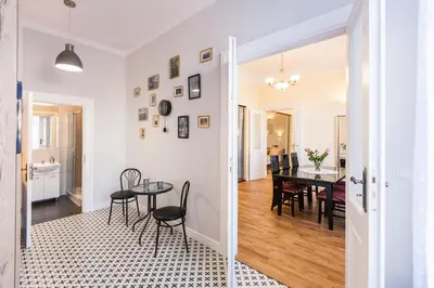 a dining room and living room with a table and chairs at Vintage Podzamcze Apartment in Kraków