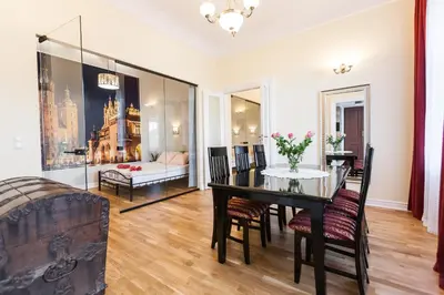 a dining room with a table and chairs and a couch at Vintage Podzamcze Apartment in Kraków