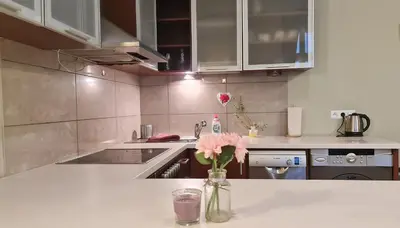 a kitchen with a vase with pink flowers in it at Bright&comfy apt -few min to Main Square in Kraków