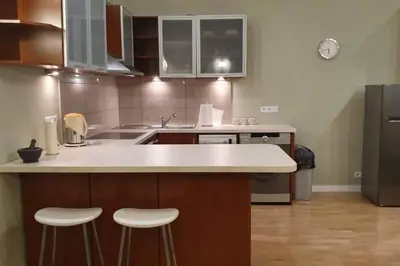 a kitchen with a counter and stools in it at Bright&comfy apt -few min to Main Square in Kraków