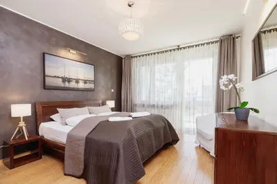 a bedroom with a large bed and a window at Apartments Obopólna Cracow by Noclegi Renters in Kraków