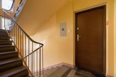 a hallway with a wooden door and stairs at Apartments Obopólna Cracow by Noclegi Renters in Kraków