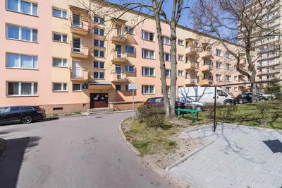 an empty street in front of a large building at Apartments Obopólna Cracow by Noclegi Renters in Kraków