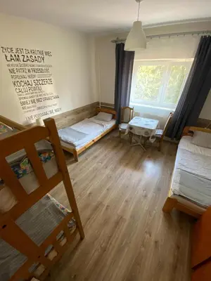 a room with two beds and a window at REKLINIEC in Myślenice