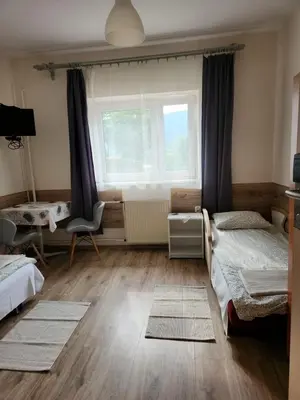 a bedroom with two beds and a window and a desk at REKLINIEC in Myślenice
