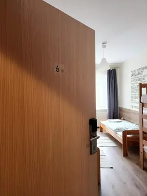 a room with a wooden door with a bed at REKLINIEC in Myślenice