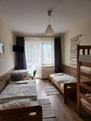 a bedroom with two bunk beds and a window at REKLINIEC in Myślenice