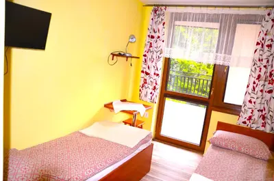 a small bedroom with a bed and a window at Ośrodek Wypoczynkowo-Szkoleniowy HALNY in Zawoja