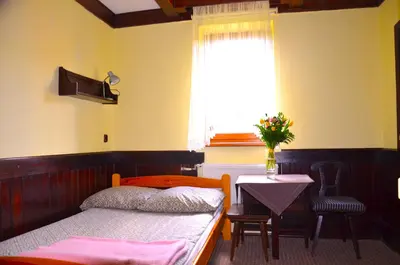 a bedroom with a bed and a table and a window at Ośrodek Wypoczynkowo-Szkoleniowy HALNY in Zawoja