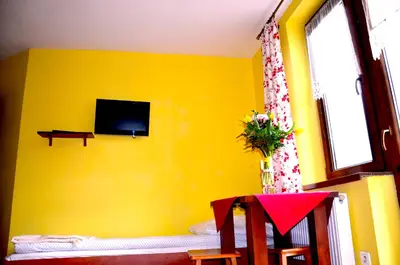 a yellow room with a tv on a yellow wall at Ośrodek Wypoczynkowo-Szkoleniowy HALNY in Zawoja