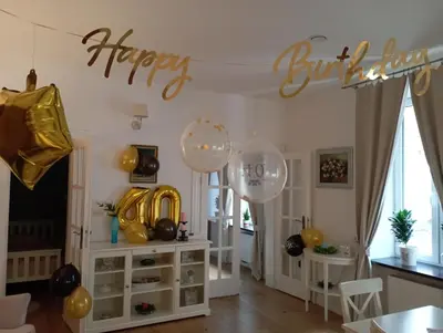 a room with balloons and a happy birthday sign on the wall at Old Town Apartment DeLux Kraków in Kraków