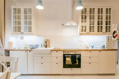 a kitchen with white cabinets and an oven at Old Town Apartment DeLux Kraków in Kraków