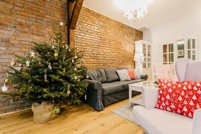 a christmas tree in a living room with a brick wall at Old Town Apartment DeLux Kraków in Kraków