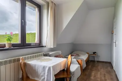 a room with two beds and a table and a window at Dom na Turystycznej in PyzÃ³wka