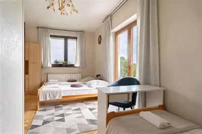 a small bedroom with a bed and a desk at Dom na Turystycznej in PyzÃ³wka