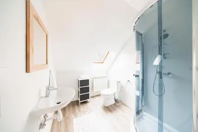 a white bathroom with a sink and a shower at Dom na Turystycznej in PyzÃ³wka