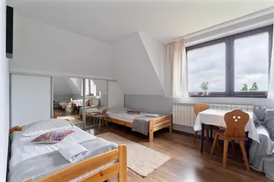 a bedroom with two beds and a table and chairs at Dom na Turystycznej in PyzÃ³wka