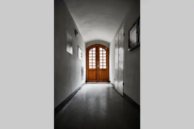 an empty hallway with a door and a window at HOUSEHOST Apartment III: Podbrzezie Street in Kraków