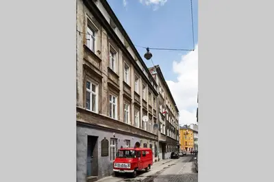 a red truck parked on a street next to a building at HOUSEHOST Apartment III: Podbrzezie Street in Kraków