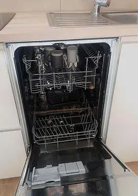 an open dishwasher with dishes inside of it at Apartamenty-Obok in Zator