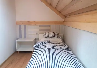 a bedroom with two beds in a room with wooden ceilings at Apartamenty-Obok in Zator