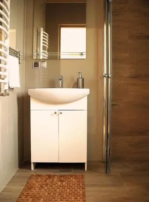 a bathroom with a white sink and a shower at Apartamenty-Obok in Zator