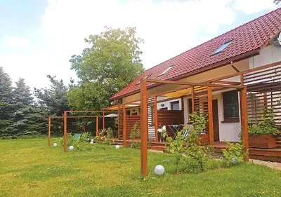 a wooden house with a grass yard next to it at Apartamenty-Obok 1 in Zator