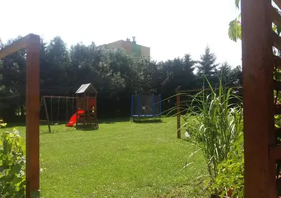 a yard with a playground with swings at Apartamenty-Obok 1 in Zator