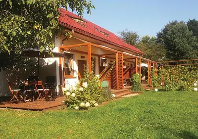 a house with a porch and a table and chairs at Apartamenty-Obok 1 in Zator