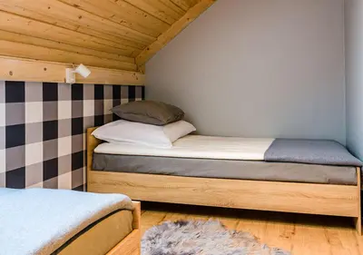 a small bedroom with two beds in a room at Apartamenty-Obok 1 in Zator