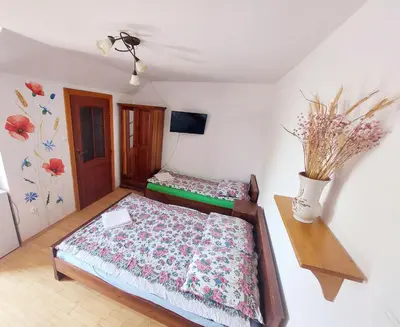 a bedroom with two beds and a vase with flowers at Wiśniowy Gaj in Ujanowice