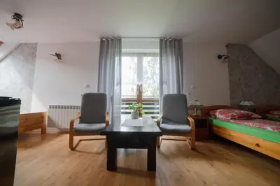 a bedroom with a bed and two chairs and a table at Wiśniowy Gaj in Ujanowice
