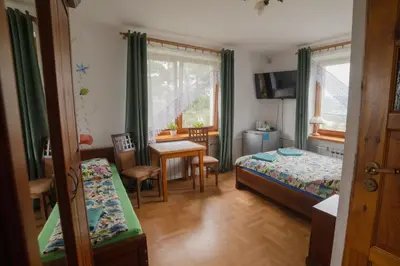 a bedroom with two beds and a table and a dining room at Wiśniowy Gaj in Ujanowice