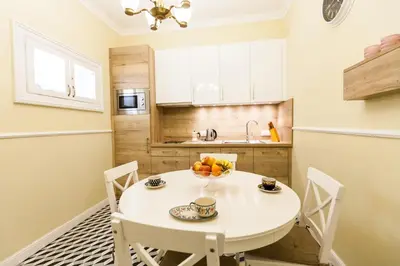 a small kitchen with a white table and chairs at Vintage Poselska Apartment in Kraków