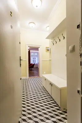 a hallway with a black and white checkered floor at Vintage Poselska Apartment in Kraków