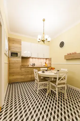 a kitchen with a table and chairs on a checkered floor at Vintage Poselska Apartment in Kraków