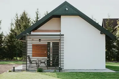 a small cabin with a bench in the grass at APARTAMENTY LAS Zator in Zator