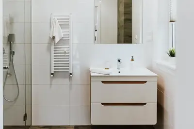 a white bathroom with a sink and a shower at APARTAMENTY LAS Zator in Zator