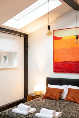 a bedroom with a bed and a painting on the wall at Pałac Zieleniewskich Apartamenty św Marka 31 in Kraków