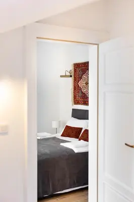 a bedroom with a bed with a door open at Pałac Zieleniewskich Apartamenty św Marka 31 in Kraków