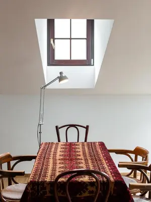 a table with chairs and a lamp and a window at Pałac Zieleniewskich Apartamenty św Marka 31 in Kraków