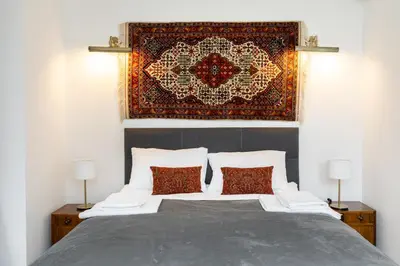 a bedroom with a bed with a rug on the wall at Pałac Zieleniewskich Apartamenty św Marka 31 in Kraków