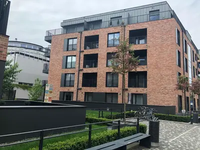 a brick building with a bench in front of it at Browar Lubicz by Atrium Apartments in Kraków