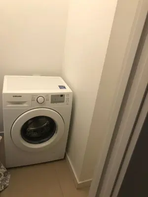 a washing machine in a corner of a room at Browar Lubicz by Atrium Apartments in Kraków