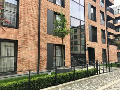 a red brick building with black windows at Browar Lubicz by Atrium Apartments in Kraków